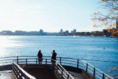 People looking at river in city