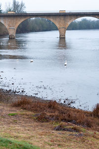 Arch bridge over river during winter