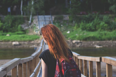 Rear view of woman standing on footbridge