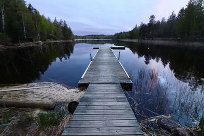 Wooden pier over lake against sky