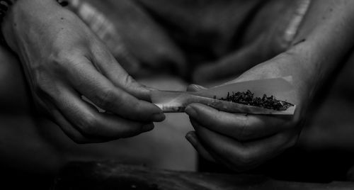 Midsection of woman holding marijuana joint