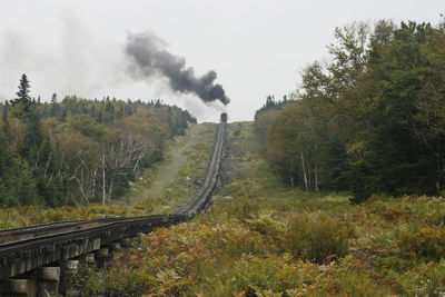 Mount washington cog railway steam train is pusing up coach to the summit at good weather conditions