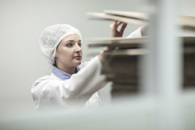 Woman in protective workwear examining cardboard boxes