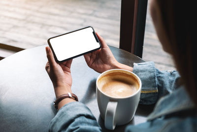 Man holding coffee cup and laptop