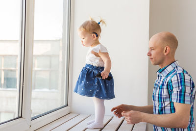 Side view of father and daughter standing on floor