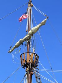 Low angle view of sailboat against blue sky