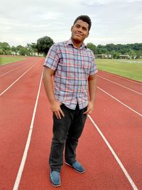 Smiling young man standing on sports track