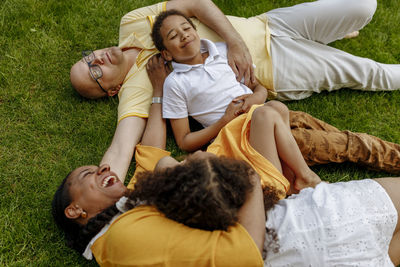 Happy woman with man and children lying on grass