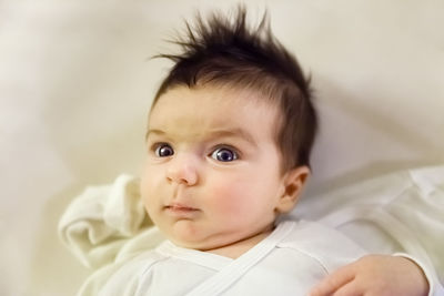 Portrait of cute baby on bed at home