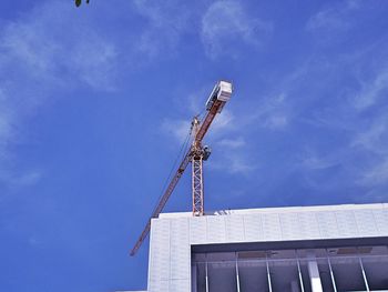 Low angle view of crane against blue sky