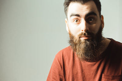 Portrait of young man against standing against gray background