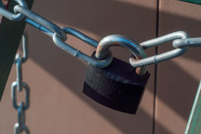 Close-up of padlocks hanging on metal fence