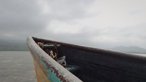 Boats in sea against cloudy sky