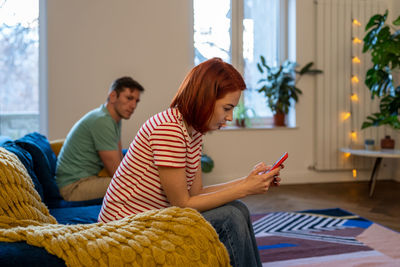 Young woman sitting on table at home