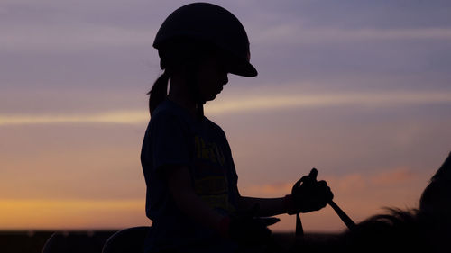 Silhouette couple against orange sky during sunset