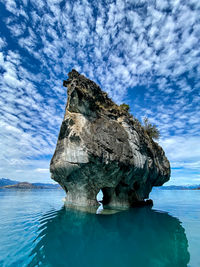 Rock formation in sea against sky