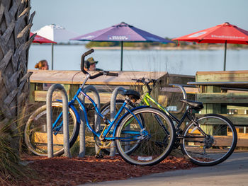 Bicycles on table by sea against sky