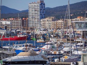 Boats moored at harbor in city