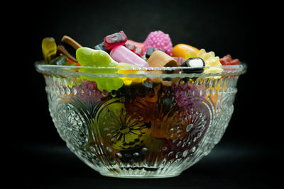 Close-up of fruits in bowl against black background