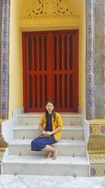 Side view of woman sitting on steps