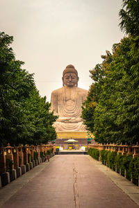 Temple against building and trees against sky