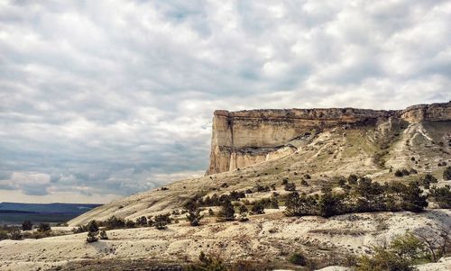 Rock formation against cloudy sky