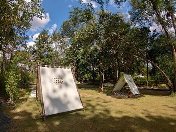 Tent against trees and plants on field