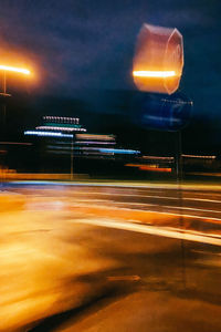 Light trails on road against sky at night