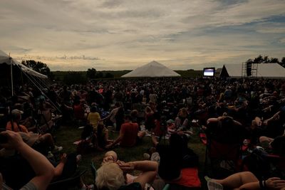 Crowd at music concert against sky