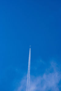 Low angle view of vapor trail against blue sky