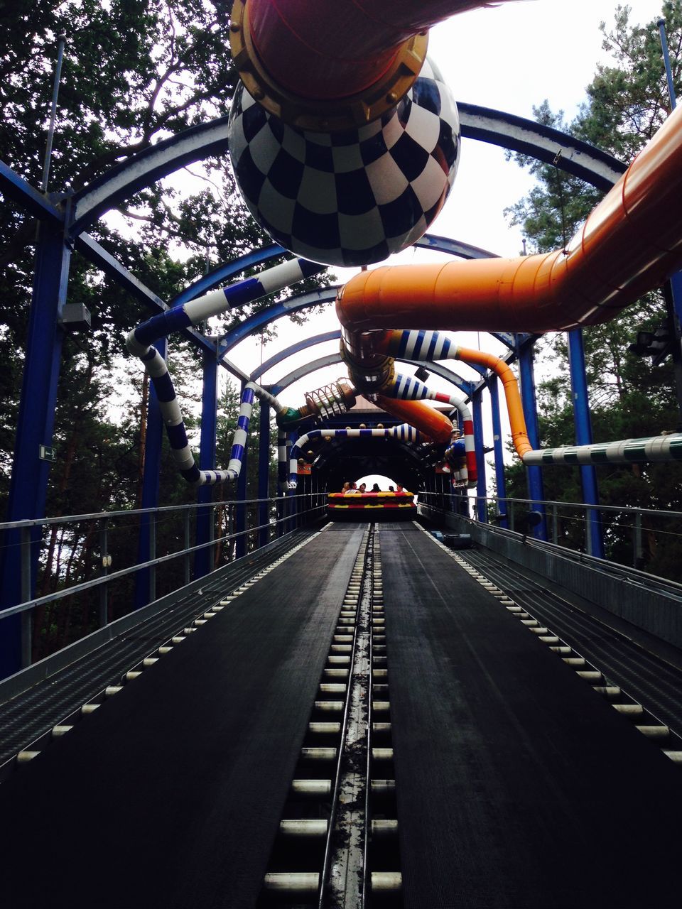 transportation, railroad track, metal, tree, built structure, rail transportation, architecture, connection, diminishing perspective, the way forward, bridge - man made structure, sky, metallic, engineering, travel, vanishing point, public transportation, no people, day, railing