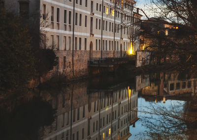 Reflection of buildings in canal at night