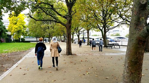 Rear view of people walking on road