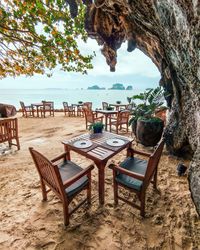 Empty chairs and table at beach