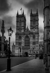 Statue in city against cloudy sky