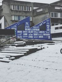Information sign on snow covered buildings in city