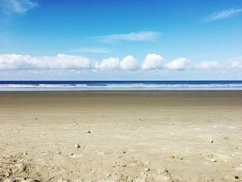 Scenic view of beach against blue sky