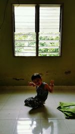 Portrait of boy on window at home