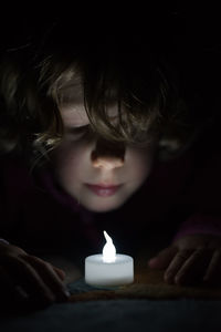 Close-up of child with illuminated face at night