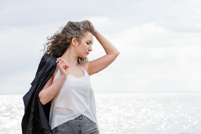 Portrait of a sad curly-haired woman by the sea