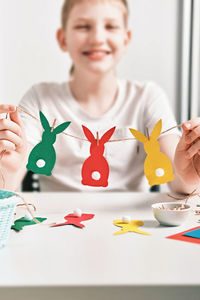 Portrait of smiling girl holding decoration on table