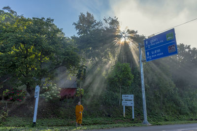 Monk standing by road signs 