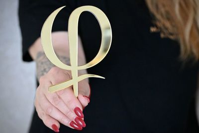 Close-up of woman holding hands over white background