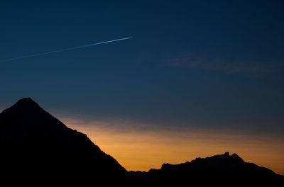 Silhouette mountain against blue sky