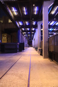 Empty illuminated corridor in building at night