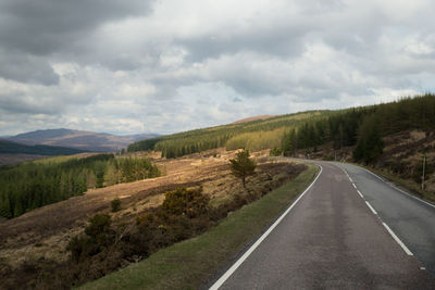 Empty road along countryside landscape