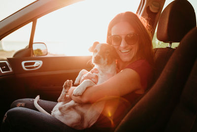 Woman sitting with dog in car