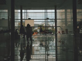 Silhouette people in building seen through glass