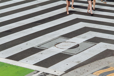 Low section of people walking on zebra crossing