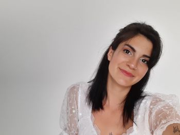 Portrait of a smiling young woman against white background